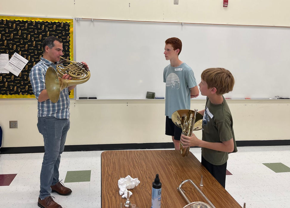 Mr. Fierova working with two french horn students